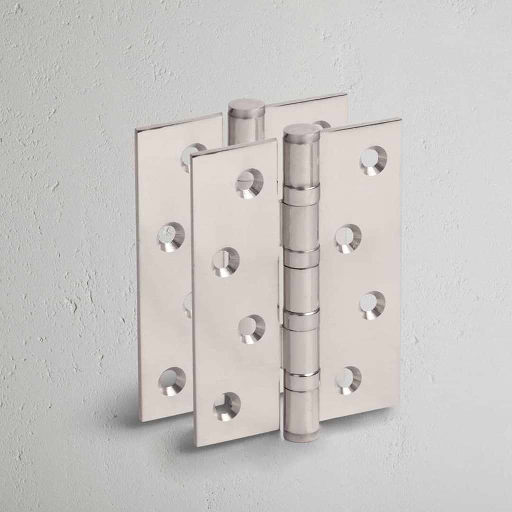 Polished Nickel Curtis Door Hinge Pair on White Background