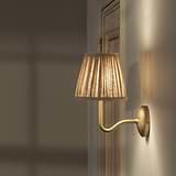 Malvern Medium Wandlamp in Naturel Beige onder een hoek bevestigd aan een muur en aangezet