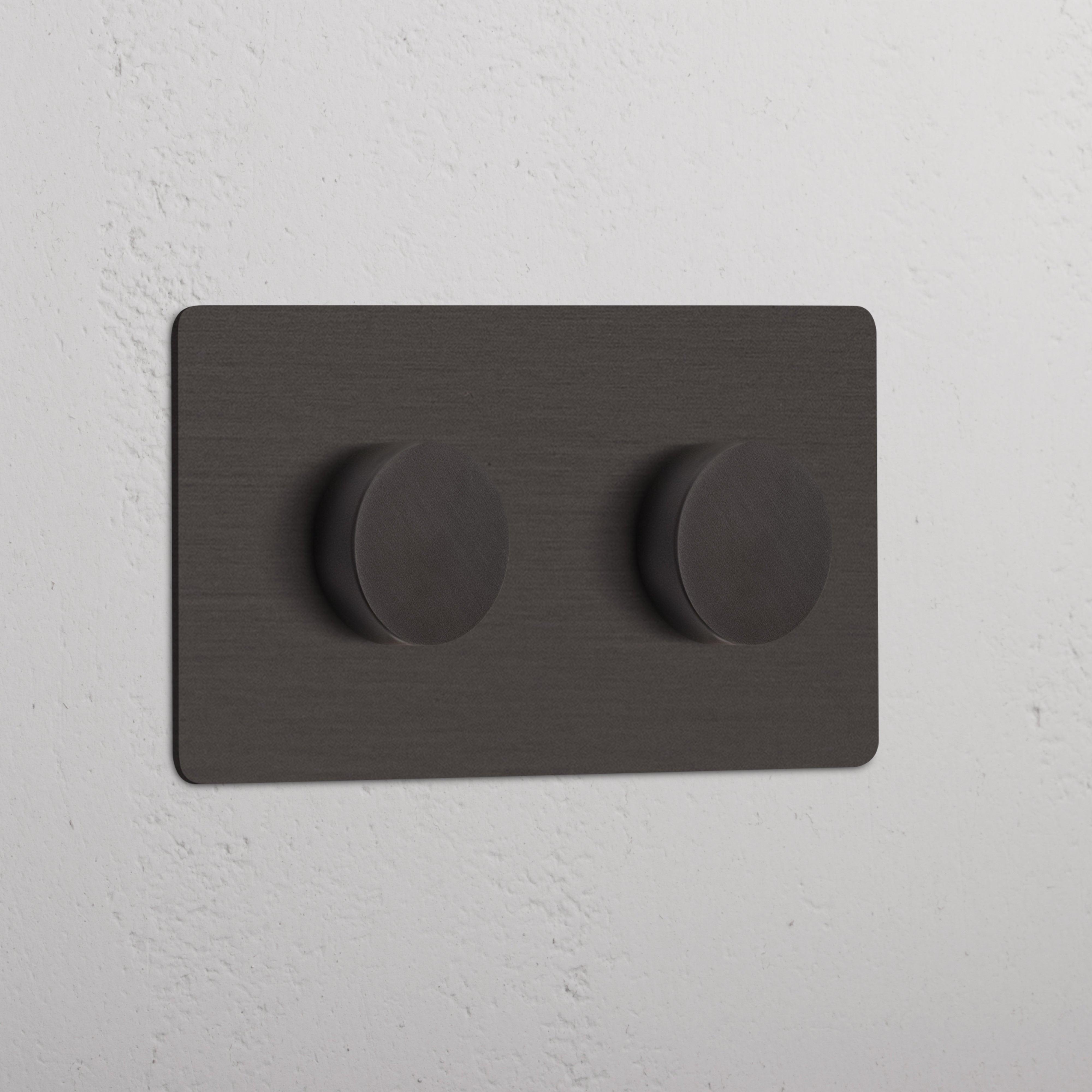 Bronskleurige dubbele afdekplaat met twee draaiknoppen voor Multicontrol Dimschakelaars, gemonteerd aan de muur.