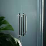Kilburn Möbelgriff 224 mm – Poliertes Nickel – an eine mattschwarze Küchenzeile montiert.