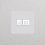Einfachrahmen mit 2x RJ45-Anschluss in lackierbar+weiß auf weißer Wand, geeignet für Ethernet-Steckdosen.