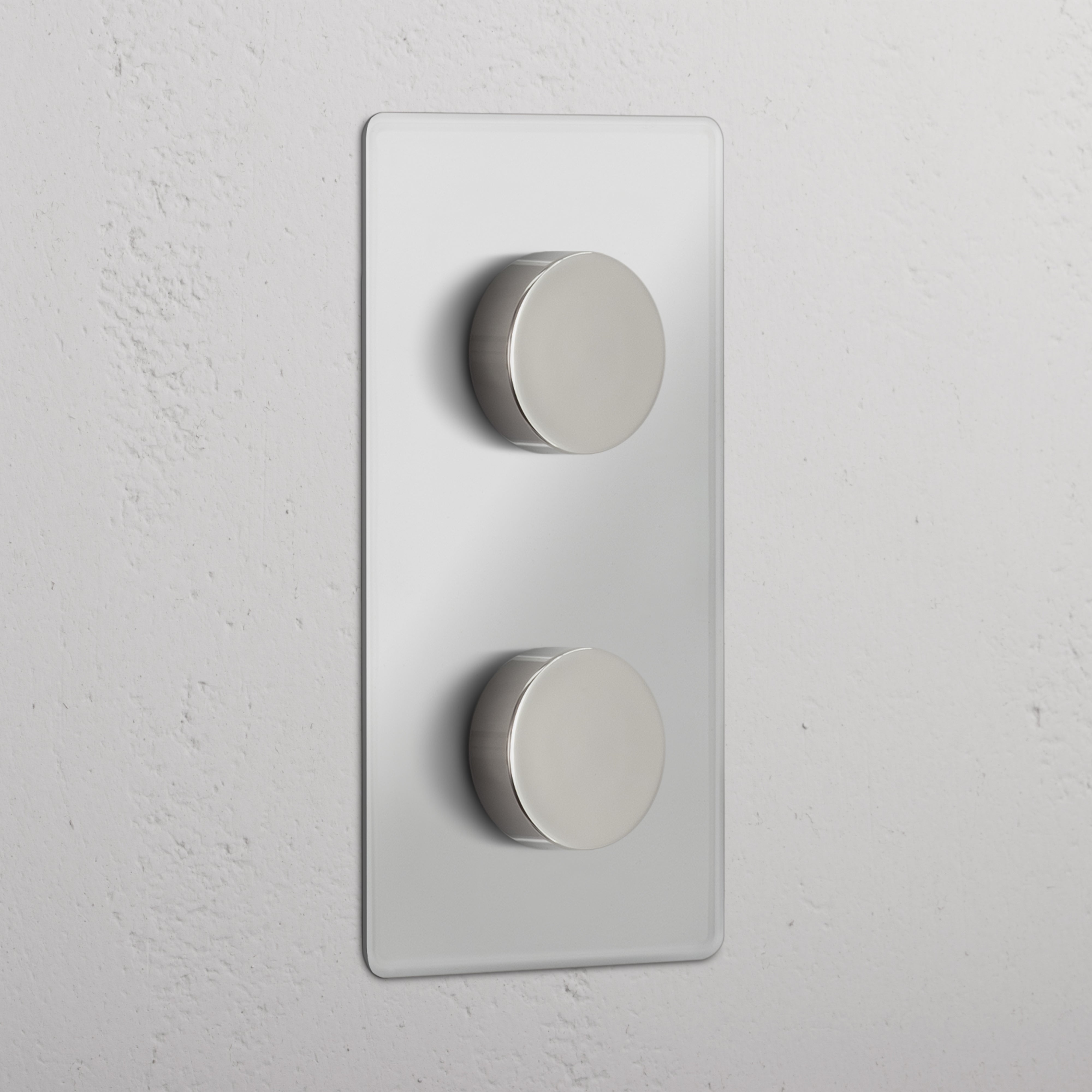 Vertikaler Zweifachrahmen mit 2x Mehrpunkt-Dimmerschalter in Transparent + Poliertes Nickel auf weißem Wand.