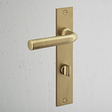 Antikes Messing Türgriff langes Schild + Drehknopf für klassische Eleganz und weißer Wand.