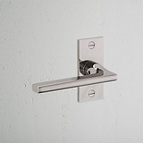 Clayton Fixer Türgriff kurzes Schild – Poliertes Nickel, elegant montiert auf einer weißen Wand.