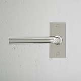 Apsley gefederter Türgriff kurzes Schild – Poliertes Nickel, rechteckige Rückplatte, montiert an weißer Wand.