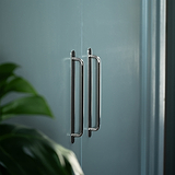 Kilburn Möbelgriff 384 mm – Poliertes Nickel – auf ein blaugrünes Möbelstück montiert.