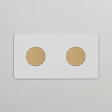 Zweifachrahmen mit 2x Dimmerknopf in antikem Messing-Look, lackierbar, auf einer strukturierten Wand.