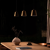 Richmond Hängeleuchte in antikem Messing über einem Tisch, bietet warmes Licht und stilvolles Design.
