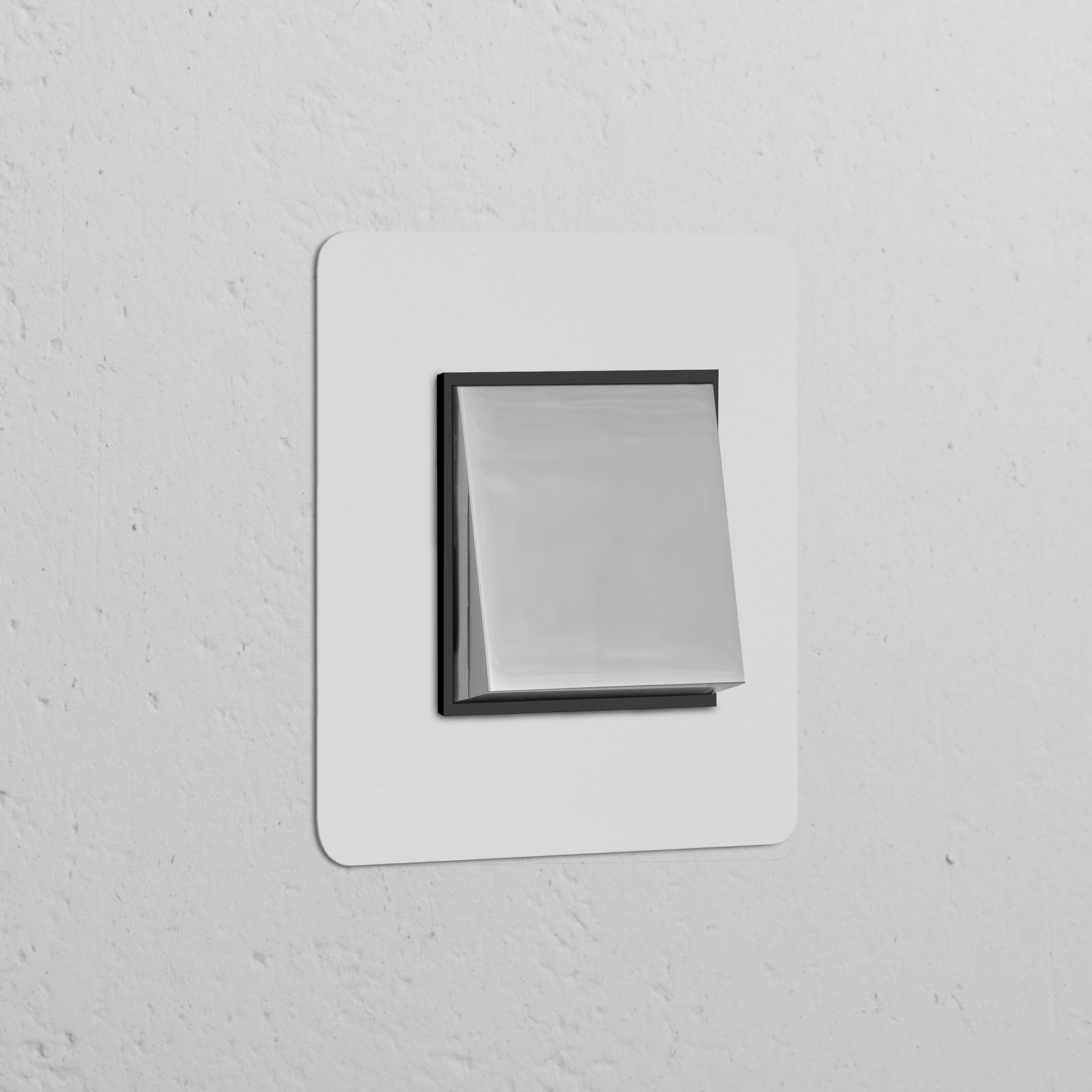 Moderner Einfachrahmen mit Wippschalter, lackierbar, poliertes Nickel und Schwarz, auf weißer Wand.