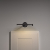 Taylor Bilderleuchte 220 mm – Bronzefarbene, wandmontierte Bilderleuchte an einer grauen Wand, die für elegante Beleuchtung sorgt.