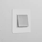 Zwischenschalter im Einfachrahmen mit Wippschalter, lackierbar, poliertes Nickel und weißes Design zur Lichtsteuerung.