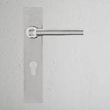 Polished nickel Harper Long Plate Sprung Door Handle with Euro Lock on a plain white wall.