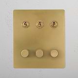 Antique Brass 6G Switch panel with three round dimmers, model 3T3D, mounted on a white wall.