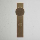 Antique Brass Onslow Long Plate Sprung Door Knob & Thumbturn on a light wall, showcasing elegant design.