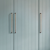 Elegant antique brass Sycamore Furniture Handle 384mm on teal paneled doors, large pull handles in vertical design.