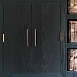 Antique brass Sycamore Furniture Handle, 224mm medium pull handle on a dark wooden cabinet.