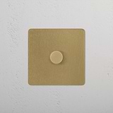 1G Two Way Dimmer Switch in Antique Brass on a white textured wall.