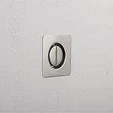 A sleek polished nickel light switch blends seamlessly into the textured white wall.