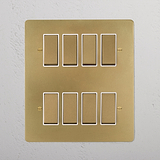 Antique Brass White 8G Two Way Rocker Switch panel with eight rectangular switches for wall installation.