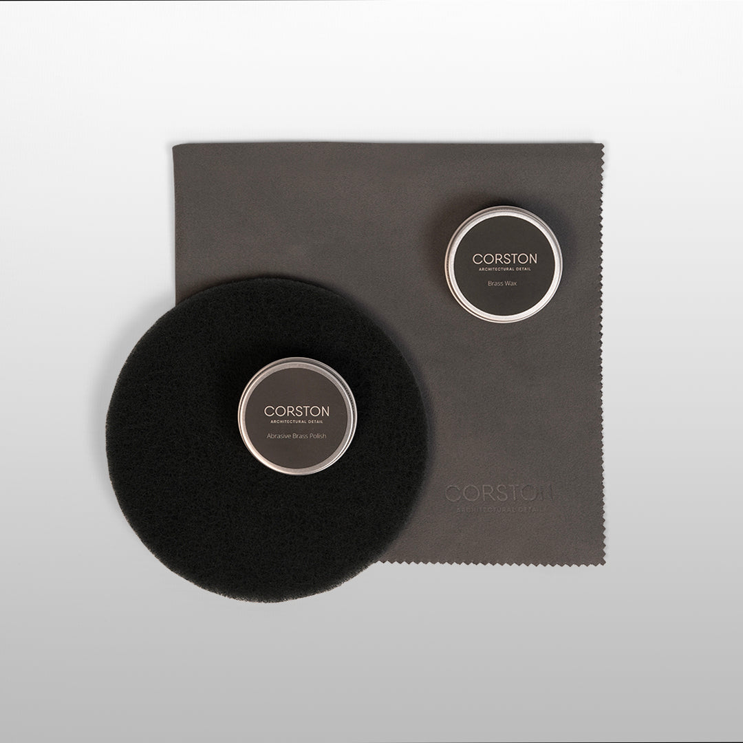 Antique Brass Restoration Kit with a black brush, two wax tins, and a cleaning cloth on a white surface.
