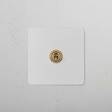 1G Intermediate Toggle Switch in paintable antique brass on a white textured wall.