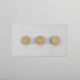 3G Dimmer Switch - Paintable Antique Brass on white panel with three knobs, mounted on a textured white wall.