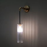Antique Brass Hanging Light Turned On On Wall With Fluted Glass