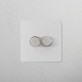 2G Dimmer Switch - Paintable Polished Nickel with two knobs, polished finish on a white panel, sleek and modern design.