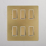 6G Two Way Rocker Switch in antique brass on a white plate, featuring six rectangular controls.