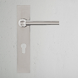 Polished nickel Harper Long Plate Sprung Door Handle with Euro Lock on a plain white wall.
