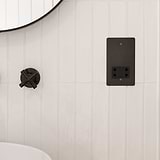 Bronze and black shaver socket fixed to white wooden slatted bathroom wall next to bronze tap and bronze framed mirror