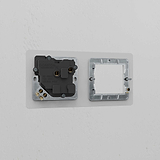 Clear Black 1G 50mm Module & Single Socket UK Plate on a white wall, featuring a sleek and modern design.