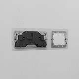 Clear Black 1G 50mm Module & Double Socket UK Plate installed on a white wall.
