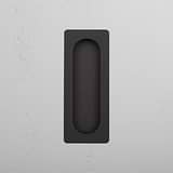 A Regent Recessed Medium Pull in elegant black adorns the textured white wall.