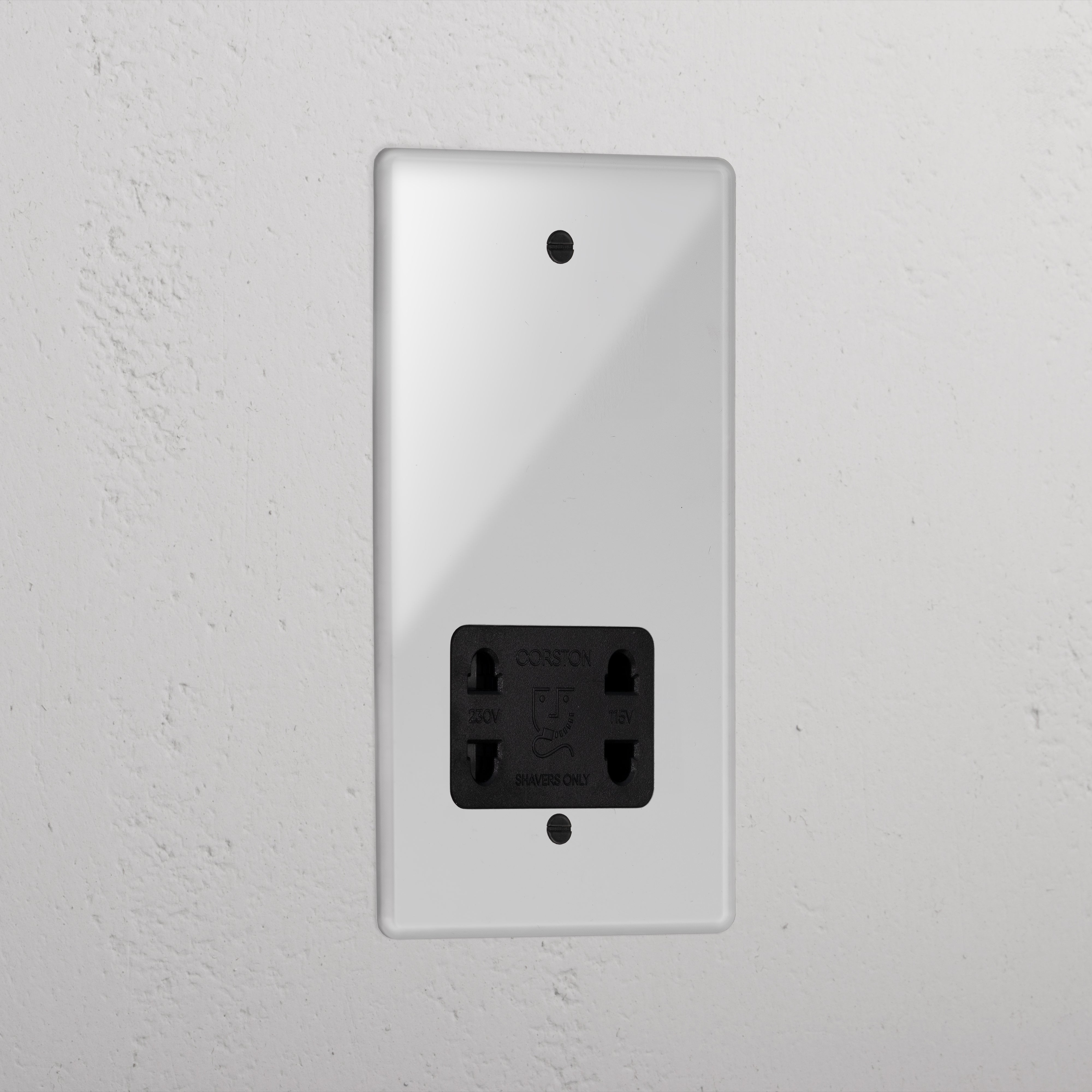 Transparent shaver socket with black insert on grey wall. 