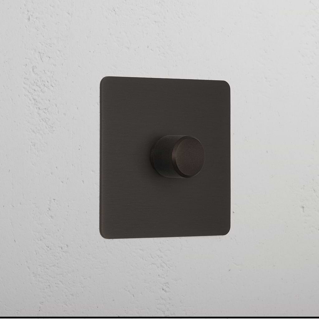 Bronze 1G digital dimmer switch with textured black square knob for controlling light intensity.