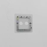 Clear 2G switch plate on a white wall, blending seamlessly into its surroundings without visible switches.