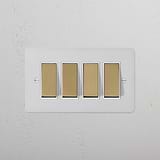 4G Two Way Rocker Switch in Paintable Antique Brass with White Finish on a textured white wall.