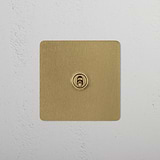 Antique brass 1G two-way toggle switch on white textured wall, part of 1G switches & dimmers collection.