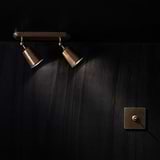 Antique brass 1G centre retractive toggle switch on a dark textured wall, part of 1G switches & dimmers collection.