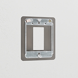 Bronze 1G Rocker Switch Plate in brass finish, mounted on a light-colored wall for a sleek modern look.