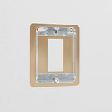 Antique brass 1G rocker switch plate on a white wall, part of the Brass Switch Plates collection.