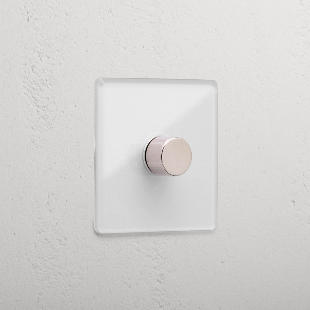 Clear polished nickel 1G digital dimmer switch with a transparent base on a white textured wall.