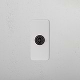 1G Architrave Centre Retractive Toggle Switch in Paintable Bronze mounted on a textured white wall.