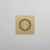 Close-up of an antique brass light switch on a white textured wall.