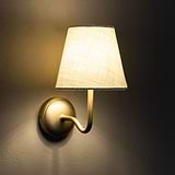 Malvern Medium Wall Light in Alabaster White and Antique Brass with a classic design, mounted on a textured wall.