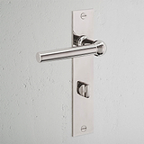 Harper Long Plate Sprung Door Handle & Thumbturn in polished nickel on rectangular backplate against a white wall.