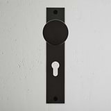 Bronze Onslow Long Plate Sprung Door Knob & Euro Lock with vertical backplate on textured white wall.