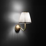 Small Malvern Wall Light in Alabaster White at an angle and turned on at night