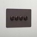 Bronze wall plate with four retractive toggle switches, '4G Toggle Retractive - Bronze'.
